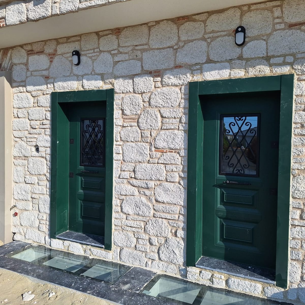 Bina girişi kesme doğal taş ve yeşil kapı detayı